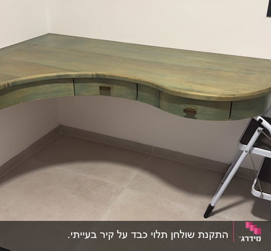 שולחן עץ ירוק עם מגירות וסולם קטן לידו